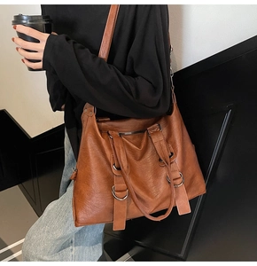 Close-up of the vintage brown leather tote bag showing large capacity and shoulder strap