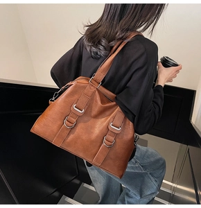 Détail d'un grand sac cabas marron sur mannequin montrant la taille et le similicuir