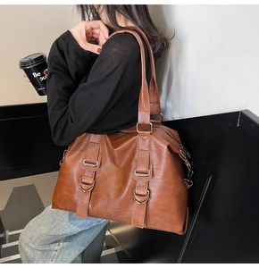 Détail d'un grand sac cabas marron avec texture vintage et boucles métalliques