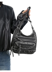 Detail view of a vintage punk shoulder bag featuring multiple pockets and metal studs