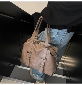 Détail du grand sac cabas taupe en similicuir mat tenu par un mannequin de côté