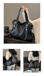 Close-up of black retro tote bag showing wrinkled leather texture and silver buckle
