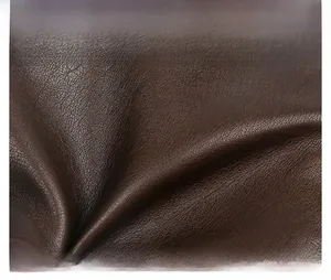 Macro shot of dark brown washed leather texture with soft lychee grain finish