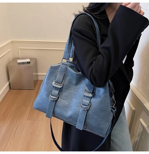 Détail du sac cabas bleu-gris texturé avec sangles parallèles et boucles argentées