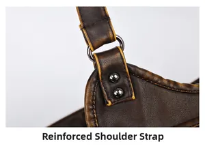 Detail of dark brown vintage leather bag showing reinforced strap with metal rivets