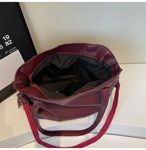 Interior view of burgundy tote bag showing spacious black lining and functional pockets