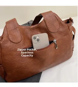 Detailed view of rear zipper pocket on brown leather tote showing smartphone storage