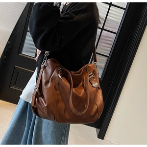 Close-up of brown PU leather tote bag featuring a vintage soft texture and silver hardware