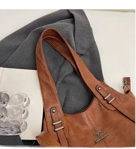 Detail of brown leather handbag featuring retro silver buckle and embossed kangaroo logo