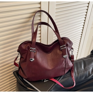 Macro shot of burgundy pebbled leather tote with silver hardware and shoulder strap
