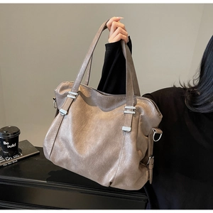 Detail shot of soft coffee brown tote bag showing natural leather texture and silver buckle