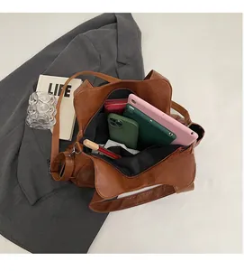 Top view of spacious interior of brown PU leather tote bag with tablet and daily items