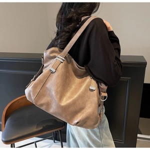 Detail of vintage clay brown leather hobo bag showing texture and silver hardware on shoulder