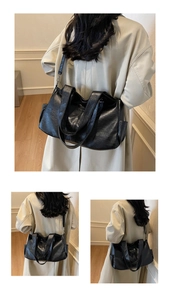 Detailed view of black tote bag featuring soft faux leather texture and side pocket design