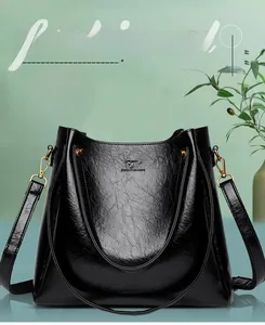 Close-up of black lychee grain leather handbag with gold hardware and logo detail