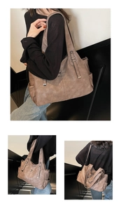 Detailed close-up of a large capacity retro brown tote bag with metal logo and shoulder strap