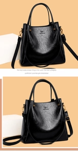 Detail of large black tote bag with litchi texture leather and gold kangaroo logo