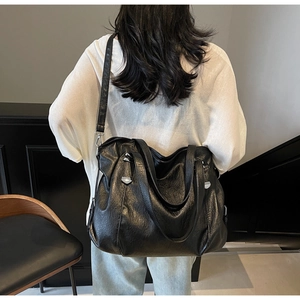 Detailed view of black vintage tote bag with oil-wax texture and silver metal buckles
