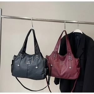 Close-up of litchi grain tote bags in black and wine red with metallic kangaroo logo