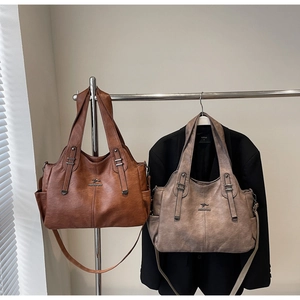 Detail of dark brown and taupe tote bags with kangaroo logo and side pockets