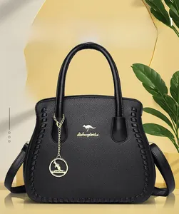 Detail of black lychee grain leather tote with gold kangaroo logo and metal charm