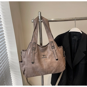 Detail of retro brown PU leather tote bag with kangaroo logo and large side pocket