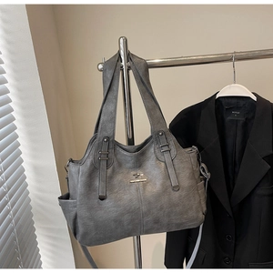 Detail of grey retro tote bag featuring a textured leather finish and kangaroo metal logo