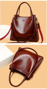 Close-up of wine red embossed leather tote featuring kangaroo logo and woven shoulder strap