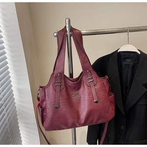 Close-up of wine red faux leather tote bag showing lychee grain and kangaroo logo