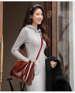 Detail of reddish-brown oil wax leather tote bag with gold hardware and shoulder strap