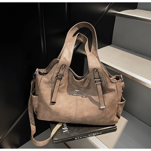 Macro shot of brown leather tote bag with metallic kangaroo logo on English book