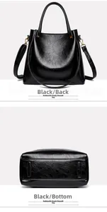 Detail view of the back and bottom of a black oil wax leather tote bag with gold hardware