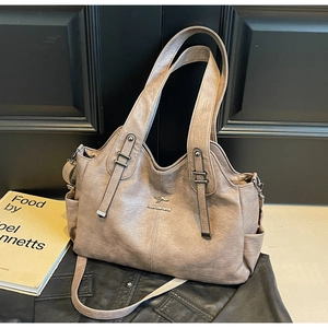 Detail of lychee textured leather tote bag in dusty pink with metal kangaroo logo