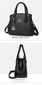 Detail view of black lychee grain leather handbag with golden logo and woven side texture