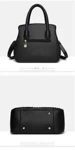 Detail view of black lychee leather handbag back zipper pocket and metal bottom rivets