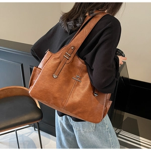 Side view of a brown vintage tote bag with kangaroo logo and side pocket on shoulder