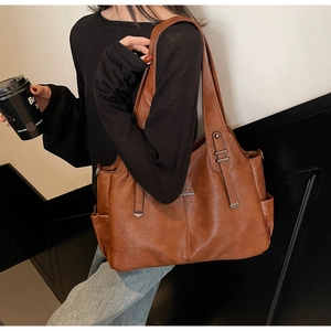 Macro detail of brown leather tote bag showing high-quality texture and kangaroo logo