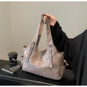 Close-up of pink leather tote bag with kangaroo logo and side pockets detail