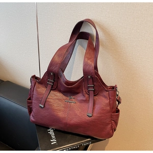 Close-up of wine red litchi texture leather handbag with metallic kangaroo logo