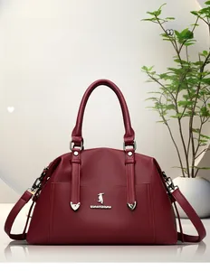 Détail d'un sac cabas bordeaux en cuir grainé avec logo kangourou doré et finitions chic