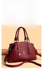 Détail du sac cabas bordeaux grainé avec logo métallique et bandoulière réglable incluse