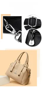 Détails de la quincaillerie argentée et du cuir grainé sur un cabas abricot