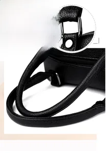 Détail du sac cabas en cuir grainé noir montrant les poignées et les ferrures argentées