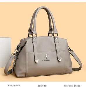 Détail du sac cabas en cuir de vachette taupe avec texture litchi et logo oiseau