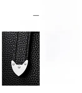 Détail du sac noir grainé avec boucle en cœur argentée et bandoulière réglable