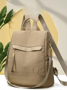 Detail of khaki corduroy backpack with cute rabbit ears and stylish gold chain tassel