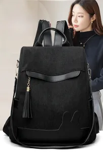 Detail of black corduroy backpack with tassel pendant and cute rabbit ear leather patch