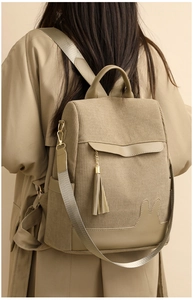 Detail view of khaki corduroy backpack featuring leather tassel and rabbit ear applique