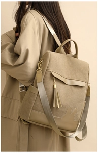 Detail of khaki corduroy backpack featuring rabbit ear patch and stylish leather tassel