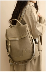 Detail of green corduroy backpack with rabbit ear decor and tassel on a stylish model